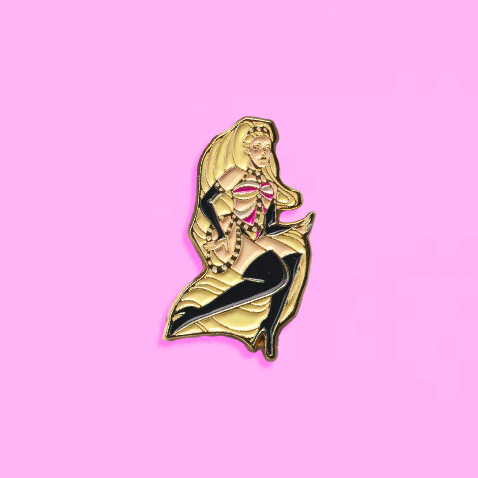 Max's enamel pin, showing her long, blonde ponytail, thigh high black boots, black gauntlets and pink, gold and black bodysuit